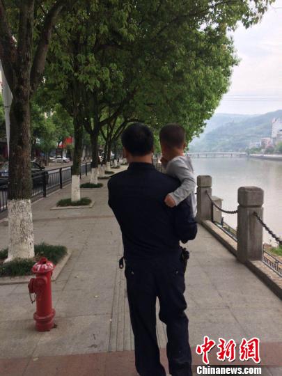 图为：民警怀抱着男孩根据其指引的方向一路向前。 文成警方供图