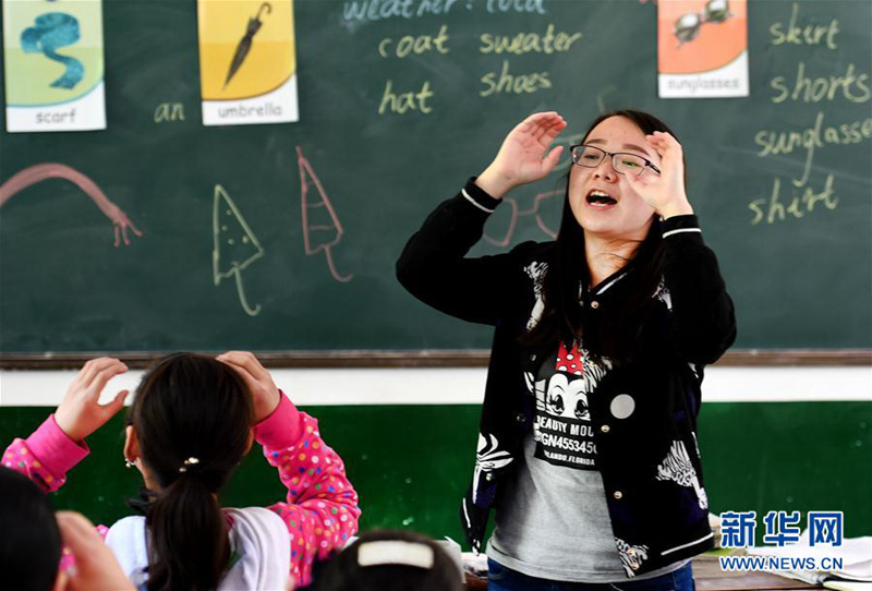 5月17日,轮岗到红鱼教学点的曾瑶老师(右)在给四年级学生上英语课。