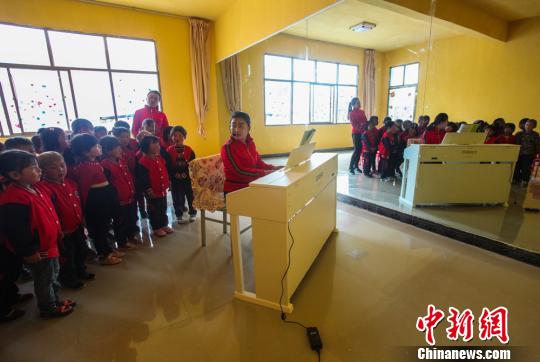 今年，武警官兵又为这所农村幼儿园配备钢琴。图为孩子们每周上一堂启蒙钢琴课。　钟欣 摄