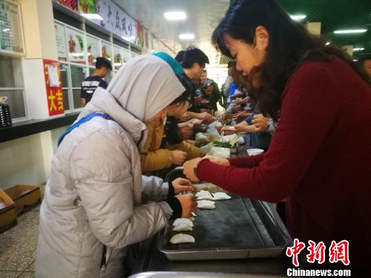 资料图：留学生在中国老师指导下包饺子。　王媛 摄