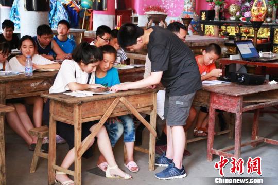图为美国华裔少年为当地孩子们教授英语。　陈水莲 摄