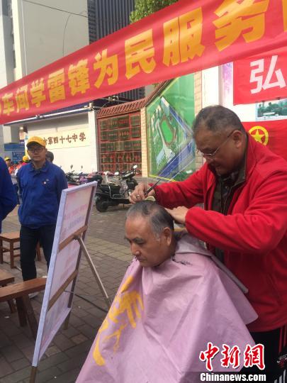 3月10日，广西柳州机车车辆厂的一名老年志愿者在为市民提供免费理发服务。　周潇男 摄
